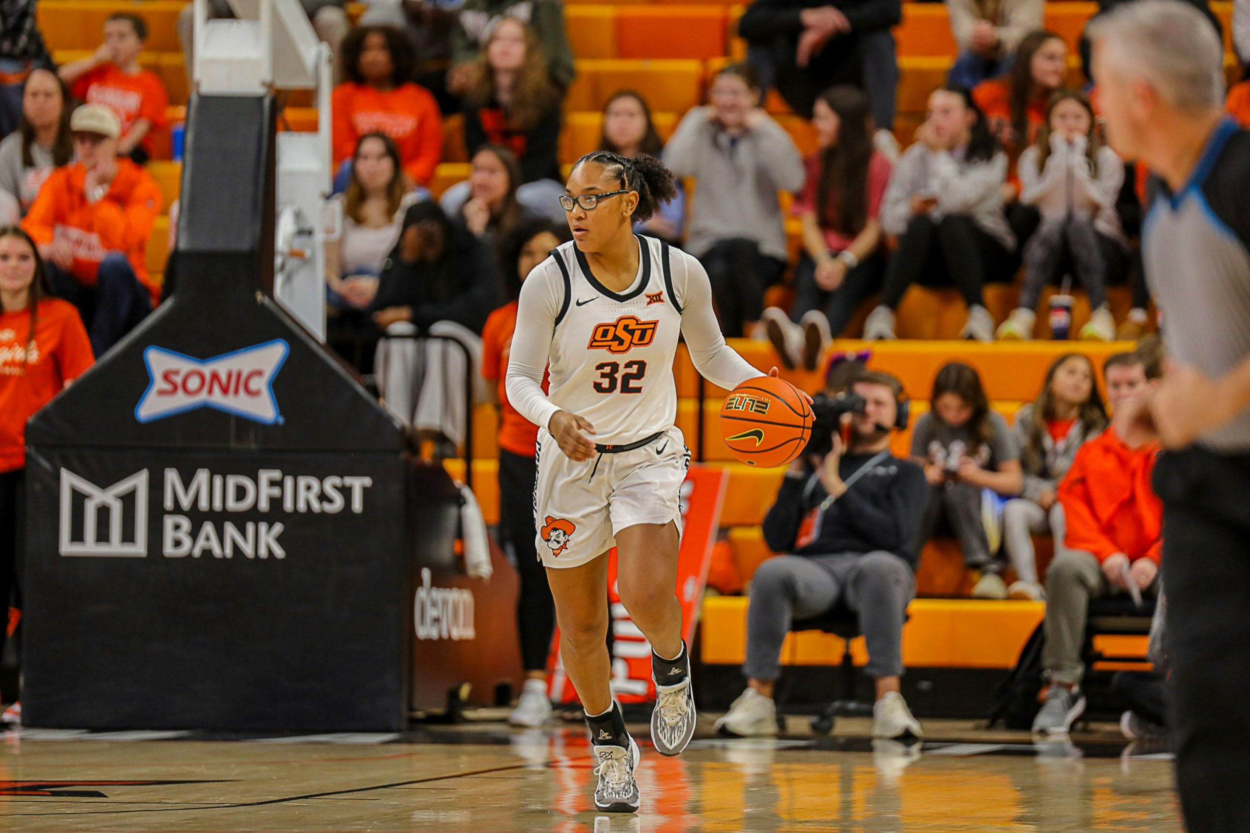 Female college basketball player dribbling, indicating benefits of this coaching module